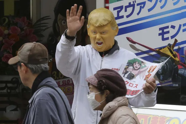 An employee advertising for a pachinko gaming parlor wears a President Donald Trump mask to attract customers in Tokyo, Saturday, Mar. 4, 2017. (Photo by Koji Sasahara/AP Photo)