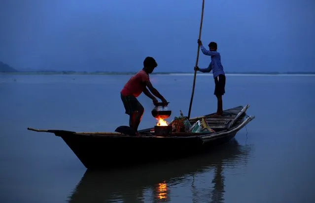 Fishermen prepare dinner before they go fishing in the river Brahmaputra in Gauhati, Assam state, India, Wednesday, April 20, 2016.Brahmaputra is one of Asia's largest rivers, which passes through China's Tibet region, India and Bangladesh before converging into the Bay of Bengal. (Photo by Anupam Nath/AP Photo)