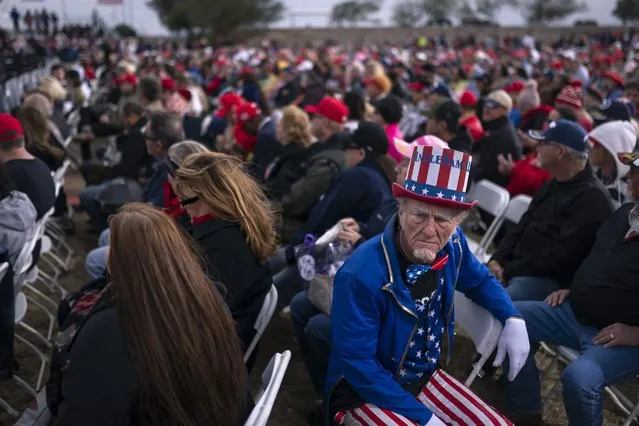 A supporter dressed as Uncle Sam listens to speakers prior to an appearance by former President Donald Trump at a rally on Saturday, January 15, 2022, in Florence, Az. (Photo by Nathan Howard/AP Photo)