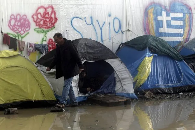 A refugee walks next to tents following heavy rainfall at a makeshift camp for migrants and refugees at the Greek-Macedonian border near the village of Idomeni, Greece, April 24, 2016. (Photo by Alexandros Avramidis/Reuters)