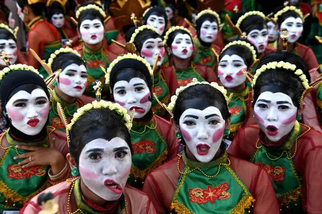 Dancers reacts to camera before they perform a Thengul dance during a festival in Bojonegoro, East Java province, Indonesia, July 14, 2019. (Photo by Zabur Karuru/Antara Foto via Reuters)