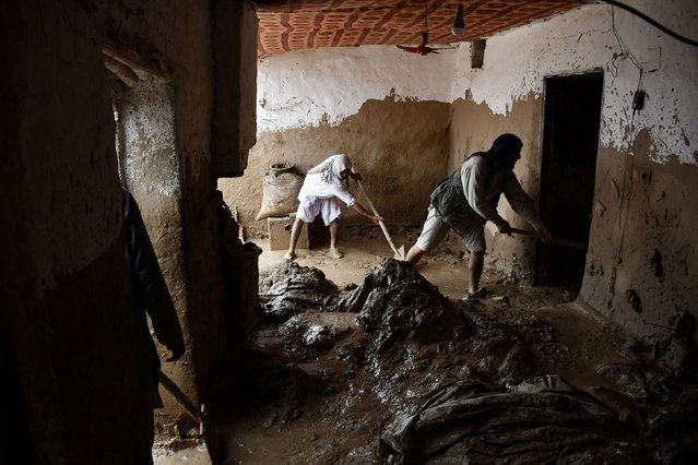 Afghan men shovel mud from a house following flash floods after heavy rainfall at a village in Baghlan-e-Markazi district of Baghlan province on May 11, 2024. More than 300 people were killed in flash floods that ripped through multiple Afghan provinces, the United Nations said on May 11, as authorities declared a state of emergency and rushed to rescue the injured. (Photo by Atif Aryan/AFP Photo)