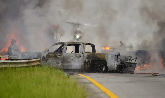 Firefighters with multiple departments battle a fire at a fatal accident involving a tanker in Spartanburg, S.C., Saturday, June 27, 2015. Officials say two people are dead following the fiery crash involving a tanker truck and at least one other vehicle on Interstate 26. S.C. Highway Patrol Lance Cpl. Bill Rhyne confirmed the two deaths in Saturday's crash. (Photo by Tim Kimzey/The Spartanburg Herald-Journal via AP Photo)