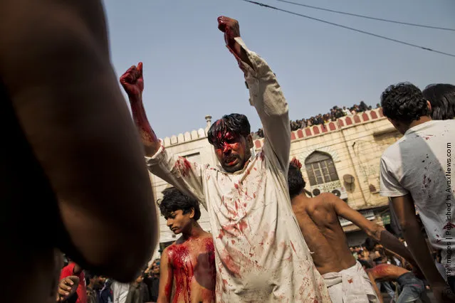 Shi'ite Muslim men and boys beat their chests as they practice self-flagellation during the religious ritual of Ashura in New Delhi, India
