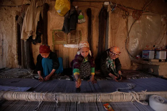 Ethnic Hazara children weave a carpet in a home workshop in their home in Turkman camp in Nowshera, Pakistan February 9, 2017. (Photo by Fayaz Aziz/Reuters)