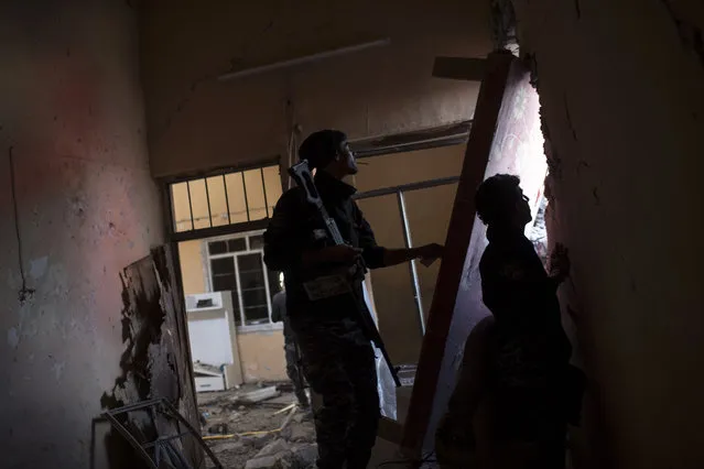 Federal policeman look towards Islamic State positions from a damaged house during fighting at the front line near the old city, on the western side of Mosul, Iraq, Wednesday, March 29, 2017. (Photo by Felipe Dana/AP Photo)