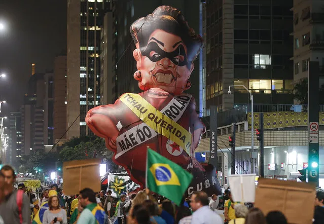 People protest next to large inflatable doll of Brazil's President Dilma Rousseff wearing a presidential sash with the words “Goodbye dear” and "Mother of Big Oil" written in Portuguese, in Sao Paulo, Brazil, Monday, May 9, 2016. Brazil's Senate leader Renan Calheiros said on Monday the Senate will vote as scheduled on a motion to open an impeachment trial against President Dilma Rousseff, despite a sudden lower house about-face. (Photo by Andre Penner/AP Photo)