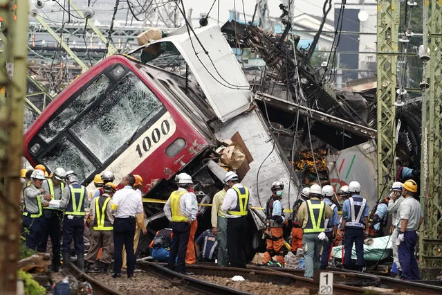 The Keikyu express train sits derailed  after its collision with a truck in Yokohama, south of Tokyo Thursday, September 5, 2019. The commuter train and a truck loaded with boxes of citrus collided at a rail crossing near Tokyo on Thursday, injuring dozens of people, Japanese authorities said. (Photo by Eugene Hoshiko/AP Photo)