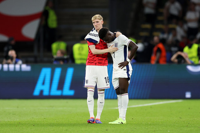 Bukayo Saka of England is consoled by Anthony Gordon after defeat during the UEFA EURO 2024 final match between Spain and England at Olympiastadion on July 14, 2024 in Berlin, Germany. (Photo by Richard Pelham/Getty Images)