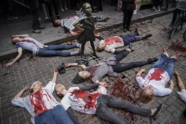 Environmental activists participate in a die-in during a rally for action against climate change near the Wall Street Fearless girl in the Financial District October 7, 2019 in New York City. The group “Extinction Rebellion” has organized protests and sit-ins around the globe today to push for action against climate change. (Photo by Drew Angerer/Getty Images)