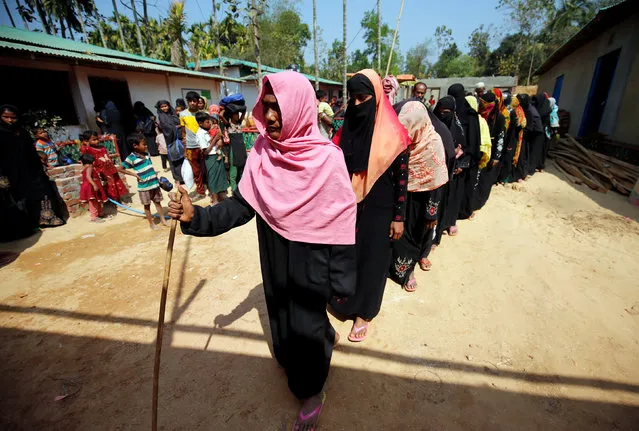 Rohingya refugees wait in a queue to collect relief, including food and medicine, sent from Malaysia at Kutupalang Unregistered Refugee Camp in Cox’s Bazar, Bangladesh, February 15, 2017. (Photo by Mohammad Ponir Hossain/Reuters)