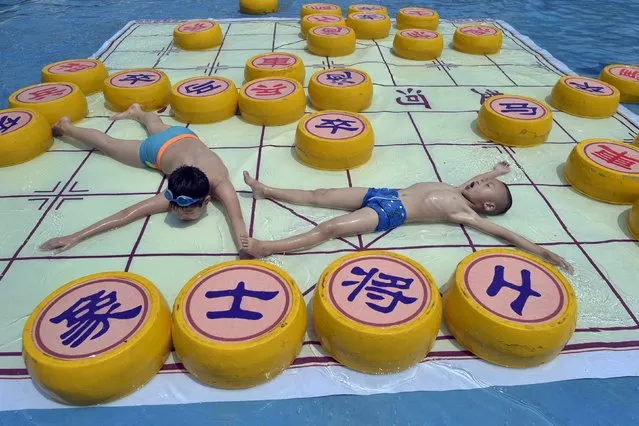 Children cool off on a 20 square meter Chinese chess board, at a water park in Chongqing municipality, July 7, 2015. (Photo by Reuters/China Daily)
