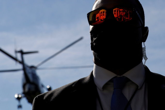 The facade of the White House is reflected in a Secret Service agent's glasses as President Joe Biden and first lady Jill Biden depart via the Marine One helicopter for travel to Delaware from the White House, on November 6, 2021. (Photo by Jonathan Ernst/Reuters)