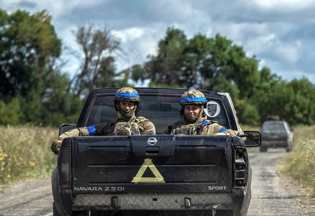 Ukrainian servicemen ride a military vehicle near the Russian border in Sumy region, Ukraine on August 13, 2024. (Photo by Viacheslav Ratynskyi/Reuters)