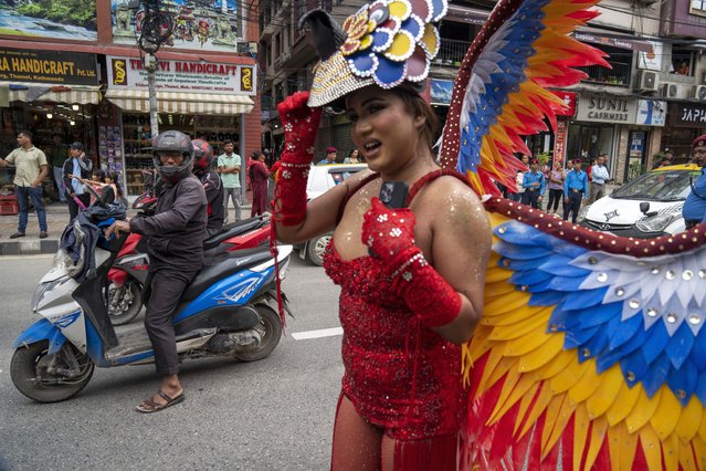 A man watches a participant poses for a photograph as LGBTQ+ people and their supporters rally during the annual pride parade, in Kathmandu, Nepal, Tuesday, August 20, 2024. (Photo by Niranjan Shrestha/AP Photo)