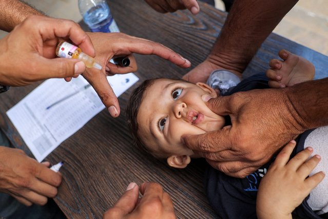 A young child is restrained before receiving a vaccination for polio in Deir el-Balah in the central Gaza Strip on September 4, 2024 amid the ongoing war in the Palestinian territory between Israel and Hamas. The World Health Organization said Israel had agreed to at least three days of “humanitarian pauses” in parts of Gaza, starting on August 31, to facilitate a vaccination drive after the territory recorded its first case of polio in a quarter of a century. (Photo by Eyad Baba/AFP Photo)