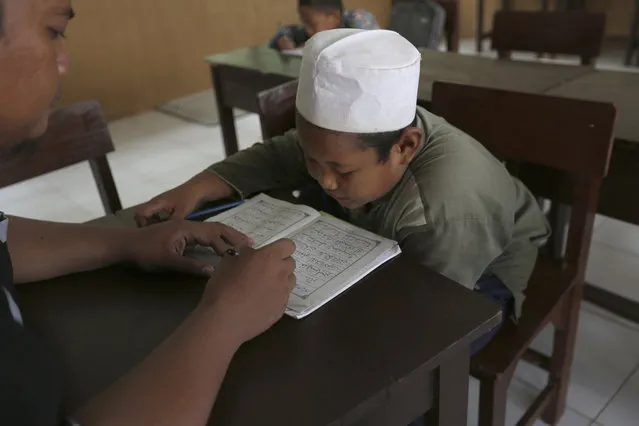A Muslim student reads the Quran at an Islamic boarding school in Tenggulun, East Java, Indonesia, on Saturday, April 27, 2019. The school is part of Ali Fauzi's Circle of Peace Foundation, which Fauzi created in a bid to combat violent extremism. (Photo by Tatan Syuflana/AP Photo)