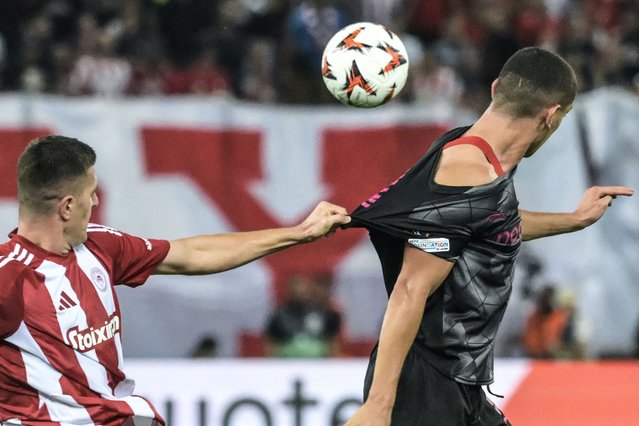 Olympiakos' Italian defender #05 Lorenzo Pirola (L) is held by Sporting Braga's French forward #09 Amine El Ouazzani during the UEFA Europa League 1st round day 2 football match between Olympiakos and Sporting Braga at Georgios Karaiskakis Stadium in Piraeus on October 3, 2024. (Photo by Angelos Tzortzinis/AFP Photo)