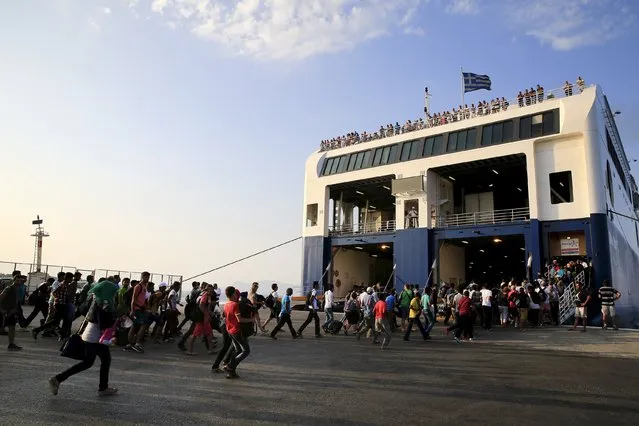 Migrants and refugees with temporary documents and a few tourists run to embark on a ferry bound for Athens at the port of the Greek island of Kos August 10, 2015. (Photo by Yannis Behrakis/Reuters)