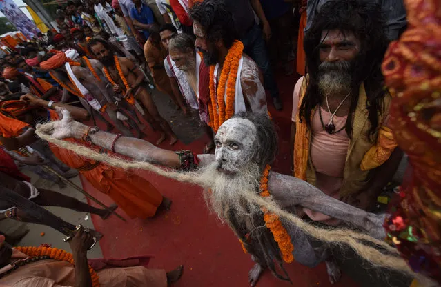 An Indian Hindu sadhu (holy man) dances in a religious procession on the eve of the annual Ambubachi festival at the Kamakhya temple in Guwahati on June 21, 2016. Thousands of Hindu devotees from all over India gather on the occasion of Ambubachi Mela, which is celebrated to mark the menstruation period of the goddess and during which occasion the sanctorum of the shrine remains closed to worshippers. The Ambubach Mela runs from June 22-26. (Photo by Biju Boro/AFP Photo)