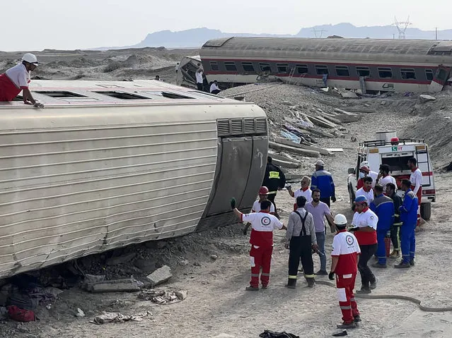 In this photo provided by Iranian Red Crescent Society, rescuers work at the scene where a passenger train partially derailed near the desert city of Tabas in eastern Iran, Wednesday, June 8, 2022. (Photo by Iranian Red Crescent Society via AP Photo)