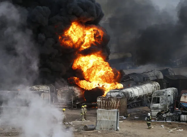 Smoke and flames rise from fuel trucks after an overnight attack by the Taliban on the outskirts of Kabul July 5, 2014. Taliban insurgents set fire on Saturday to about 200 oil tanker trucks supplying fuel for NATO forces in an attack just outside the Afghan capital Kabul, police said. (Photo by Mohammad Ismail/Reuters)