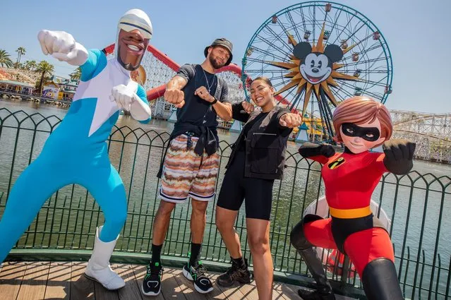 In this handout photo provided by Disney Resorts, American professional basketball player Stephen Curry and Canadian-American actress Ayesha Curry pose with Frozone and Mrs. Incredible at Disney California Adventure Park on July 14, 2022 in Anaheim, California. (Photo by Christian Thompson/Disneyland Resort via Getty Images)