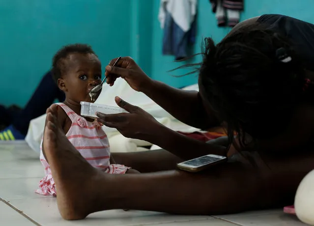 An African migrant stranded in Costa Rica, feeds her daughter at a temporary shelter near the border between Costa Rica and Nicaragua, in Penas Blancas, Costa Rica, July 14, 2016. (Photo by Juan Carlos Ulate/Reuters)