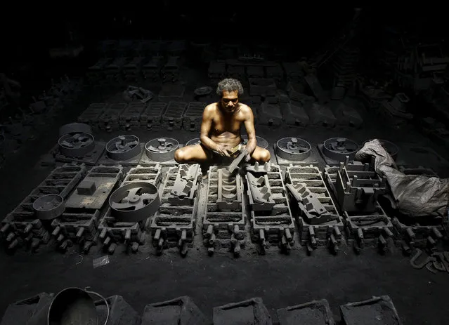 A labourer works inside the manufacturing unit of iron parts at a factory on the outskirts of Kolkata, India, September 11, 2015. (Photo by Rupak De Chowdhuri/Reuters)