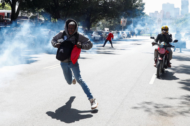 A man runs after riot police lobbed teargas canisters to disperse activists and civil society members, as they participate in a nationwide march titled “End Femicide Kenya” to raise awareness about gender-based violence (GBV) and to pressure the Kenyan government to implement stricter laws and policies to combat this pervasive issue, in downtown Nairobi, Kenya on December 10, 2024. (Photo by Thomas Mukoya/Reuters)
