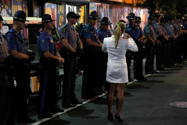 A woman photographs police officers standing guard outside the Republican National Convention in Cleveland, Ohio, U.S., July 21, 2016. (Photo by Andrew Kelly/Reuters)