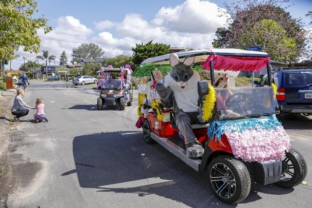 Lawyer Jessica Pride drives her husband, dressed as the Easter Bunny, as they try to bring some joy to the kids in their neighborhood during the outbreak of the coronavirus disease (COVID-19) in Solana Beach, California, U.S., April 11, 2020. (Photo by Mike Blake/Reuters)