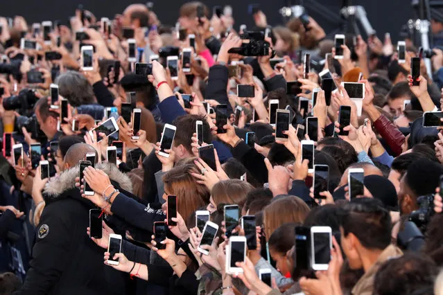 People use their smartphone to take photos of the L'Oreal fashion show on the Champs Elysees avenue during a public event organized by French cosmetics group L'Oreal as part of Paris Fashion Week, France, October 1, 2017. (Photo by Charles Platiau/Reuters)