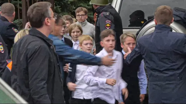 In this image taken from video, school children run from the scene of a shooting at school No. 88 in Izhevsk, Russia, Monday, September 26, 2022. Authorities say a gunman has killed 15 people and wounded 24 others in the school in central Russia. According to officials, 11 children were among those killed in the Monday morning shooting. (Photo by Izhlife.ru via AP Photo)