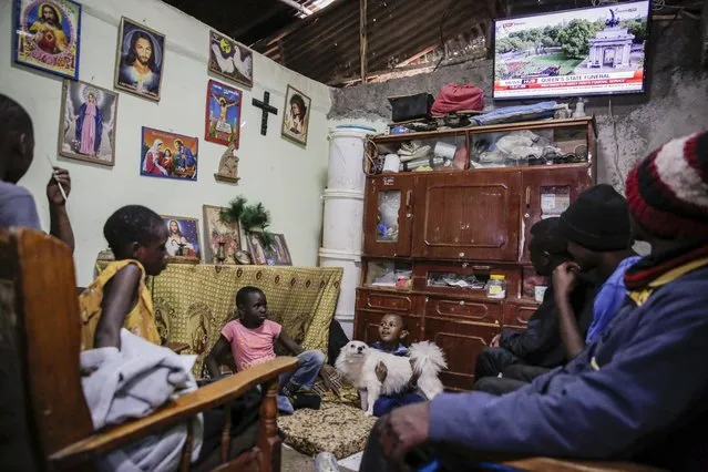 A family watches television coverage of the state funeral of Britain's Queen Elizabeth II, at their home in the low-income Kibera neighborhood of Nairobi, Kenya Monday, September 19, 2022. The Queen, who died aged 96 on Sept. 8, will be buried at Windsor alongside her late husband, Prince Philip, who died last year. (Photo by Brian Inganga/AP Photo)