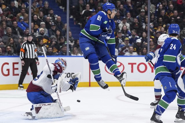 Vancouver Canucks' Dakota Joshua (81) jumps to avoid the puck as it goes wide of the net behind Colorado Avalanche goalie MacKenzie Blackwood (39) during the third period of an NHL hockey game in Vancouver, British Columbia, Tuesday, February 4, 2025. (Photo by Darryl Dyck/The Canadian Press via AP Photo)
