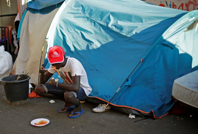 A migrant eats at a makeshift camp in Via Cupa (Gloomy Street) in downtown Rome, Italy, August 1, 2016. (Photo by Max Rossi/Reuters)