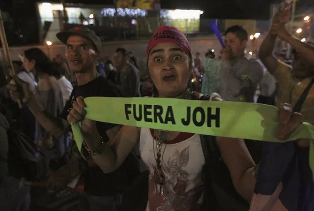 A demonstrator gestures as she holds a headband reading “Juan Orlando Hernandez out” during a march to demand the resignation of Honduras' President Hernandez in Tegucigalpa, September 11, 2015. The protesters are calling for the resignation of Hernandez over a $200-million corruption scandal at the Honduran Institute of Social Security. (Photo by Jorge Cabrera/Reuters)