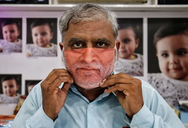 A man tries on a face mask with his portrait printed on it, amid the spread of the coronavirus disease (COVID-19), at a photo studio in Gandhinagar, India, May 27, 2020. (Photo by Amit Dave/Reuters)