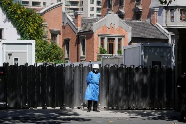 A security guard in a protective suit stands guard in front of a gate, following the coronavirus disease (COVID-19) outbreak, in Shanghai, China on October 10, 2022. (Photo by Aly Song/Reuters)