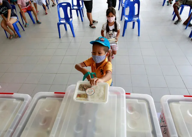 People from low-income communities receive free lunch boxes from volunteers during the coronavirus disease (COVID-19) outbreak in Bangkok, Thailand on May 13, 2020. (Photo by Soe Zeya Tun/Reuters)