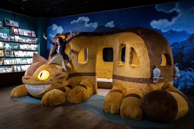 A member of the media has her photograph taken with an exhibit at Ghibli's Grand Warehouse during a media tour of the new Ghibli Park in Nagakute, Aichi prefecture on October 12, 2022. (Photo by Yuichi Yamazaki/AFP Photo)