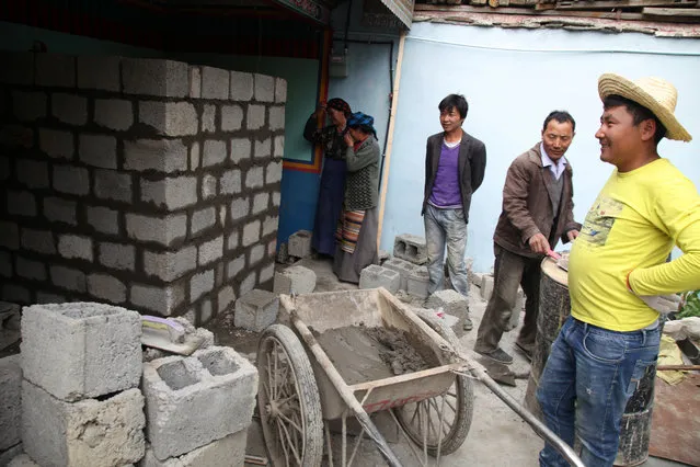 Local laborers and neighbors oversee the construction of a toilet in Lhoka county (Shannan county in Chinese) in the Tibet Autonomous Region in China, Saturday, September 19, 2015. The construction was partially funded by the local government as part of an urbanization project launched by the region's government to settle herders and nomads in villages closer to populated areas. (Photo by Aritz Parra/AP Photo)