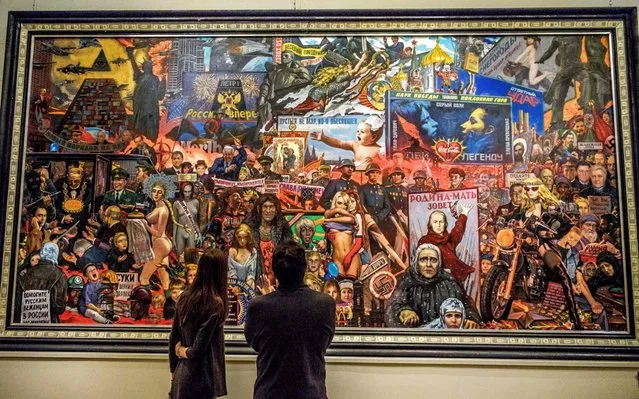 Visitors look at the monumental painting “The Market of Our Democracy” by Russian painter Ilya Glazunov exhibited at his gallery in downtown Moscow on November 19, 2017. Many Moscow museums and galleries offer free admission on the third Sunday of each month. (Photo by Mladen Antonov/AFP Photo)