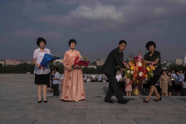 North Koreans prepare to pay their respects to the statues of former North Korean leaders Kim Il-Sung and Kim Jong-Il, at Mansu hill in Pyongyang on July 7, 2016. (Photo by Ed Jones/AFP Photo)
