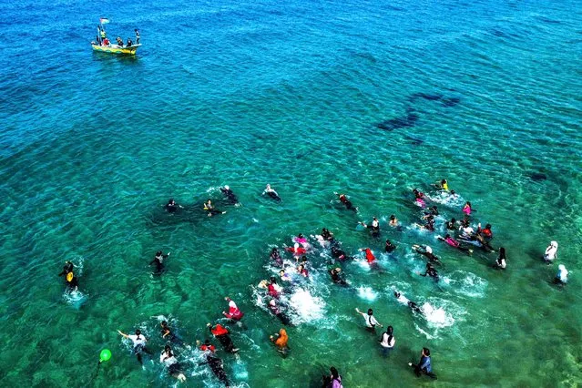 This picture taken on November 3, 2022 shows an aerial view of Palestinian girls taking part in a swimming festival in the Mediterranean sea waters off of Beit Lahia in the northern Gaza Strip. (Photo by Mahmud Hams/AFP Photo)