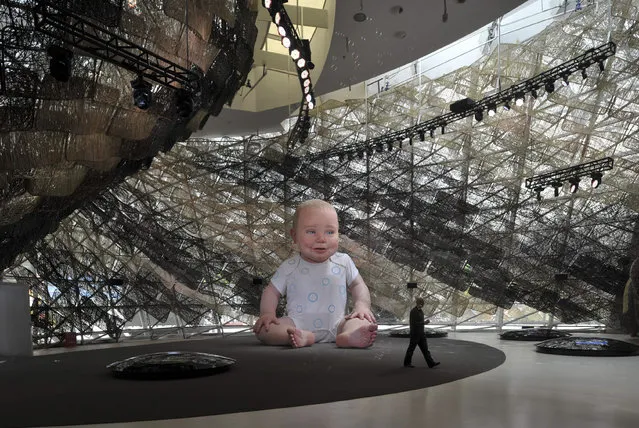 A visitor walks past an electronically animated giant baby inside the Spain pavilion at the Shanghai World Expo site April 27, 2010. (Photo by Reuters/Stringer)