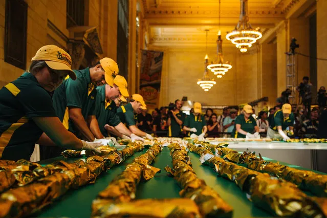 Nathan's workers participate in the event filling and wrapping up the hotdogs as Nathan's Famous attempts to break the Guinness World Record title for world's longest line of hot dogs, in Vanderbilt Hall in Grand Central Terminal in Manhattan, New York, USA, 02 September 2016, In celebration of its 100th anniversary. (Photo by Alba Vigaray/EPA)