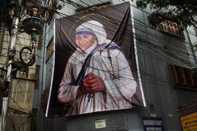 A giant picture of Mother Teresa is displayed outside the Missionaries of Charity Mother house in Kolkata, India, Saturday, September 3, 2016. For many of the poor and destitute whom Mother Teresa served, the tiny nun was a living saint. Many at the Vatican would agree, but the Catholic Church nevertheless has a grueling process to make it official, involving volumes of historical research, the hunt for miracles and teams of experts to weigh the evidence. In Mother Teresa's case, the process will come to a formal end Sunday when Pope Francis declares the church's newest saint. (Photo by Bernat Armangue/AP Photo)