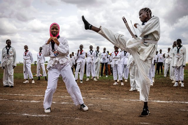 Ajok Chol, 18, a South Sudanese refugee (L), performs a taekwondo kick during a sparring demonstration with another refugee girl as part of a showcase performance at a sports day event at the Kalobeyei Sports Complex in Kalobeyei, Kenya on March 28, 2025. (Photo by Luis Tato/AFP Photo)